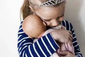 child little girl hugging doll